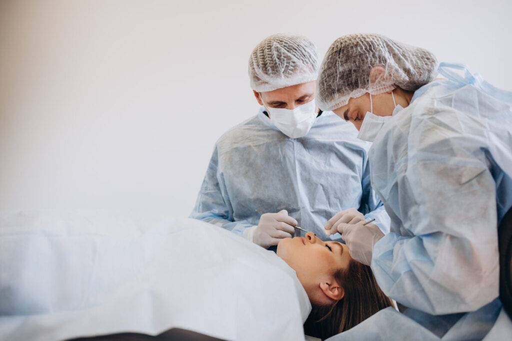 a group of people in scrubs and gloves performing surgery